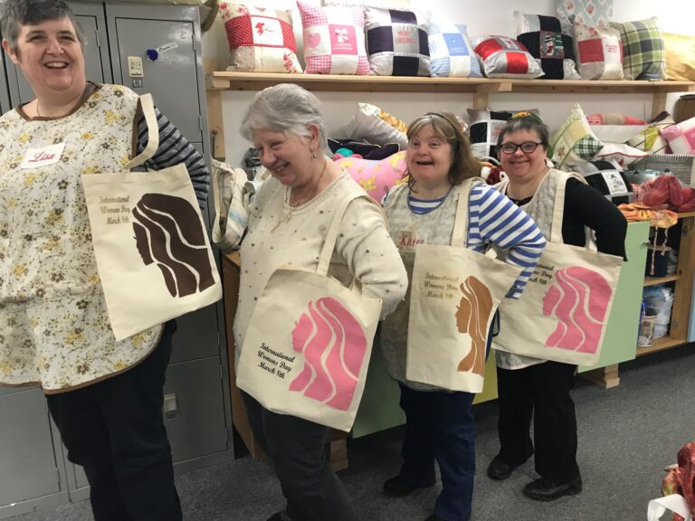 Member of South Hub wearing matching tote bags