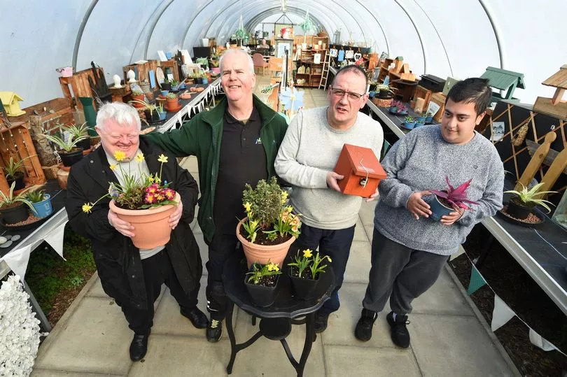 Group of people standing with plants