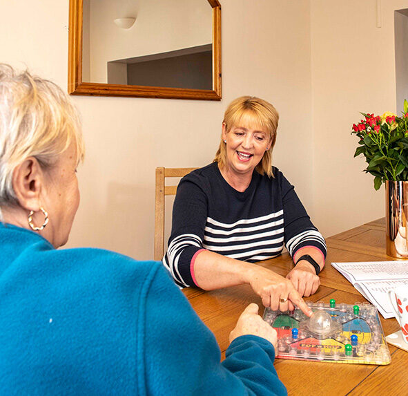 Two women playing a board game on a table