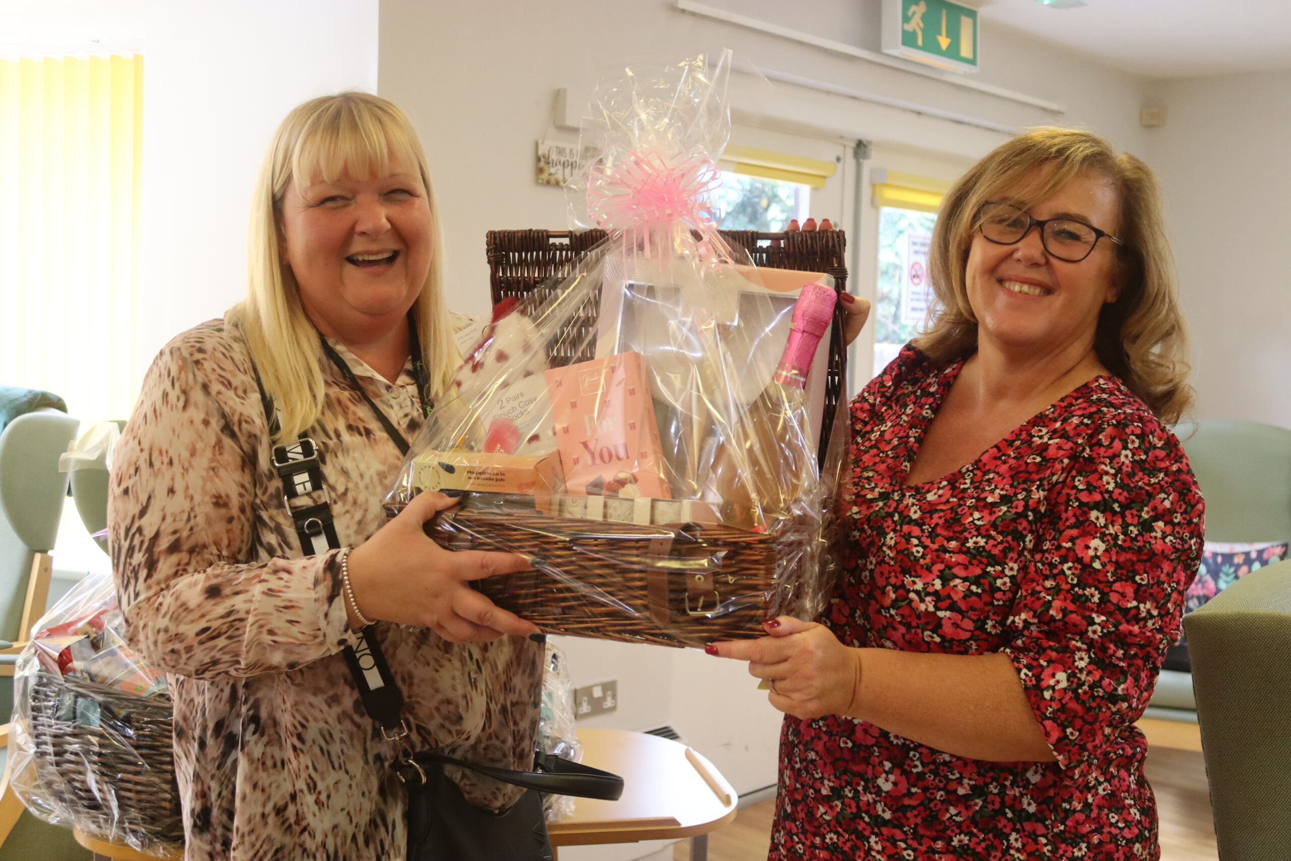 Two woman posing with winning raffle prize