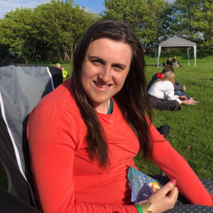 Hannah smiling, sitting in a field