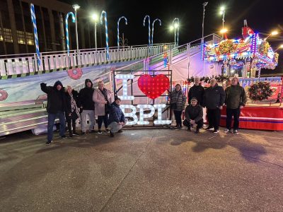 A group out at blackpool posing next to a sign