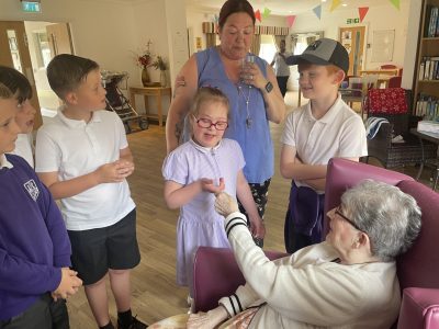 Children visiting elderly woman in care home