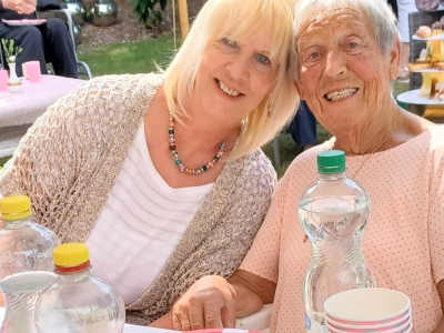 Patricia and Jean smiling sat outside