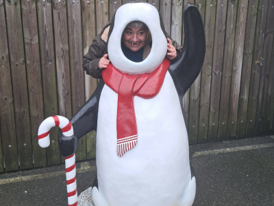 South Hub Member posing behind a penguin cutout