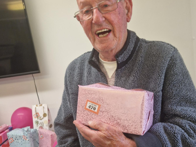 Elderly man holding a present smiling